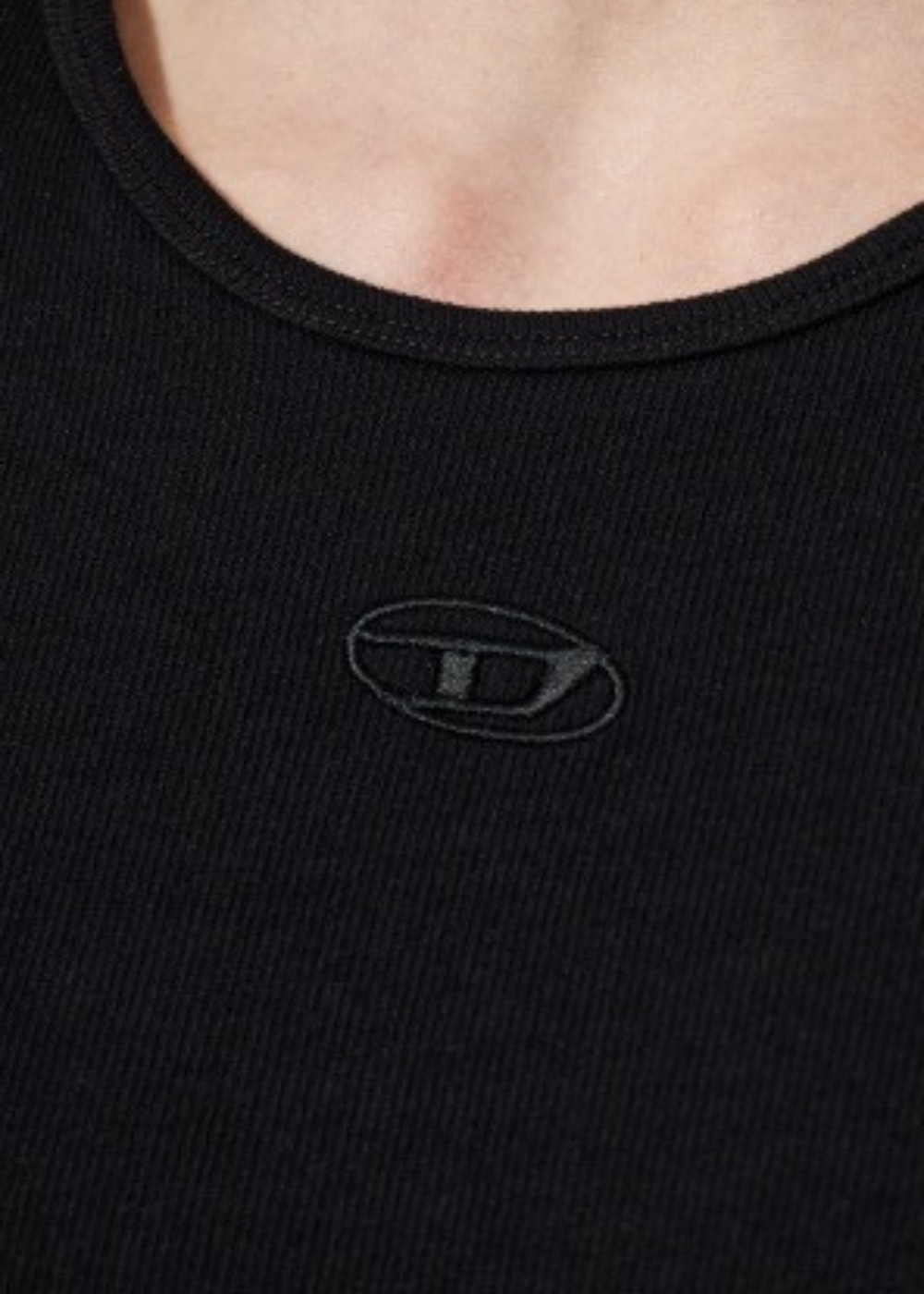 Gros plan sur le logo D ton sur ton brodé sur l'encolure du débardeur homme Diesel noir en coton côtele
