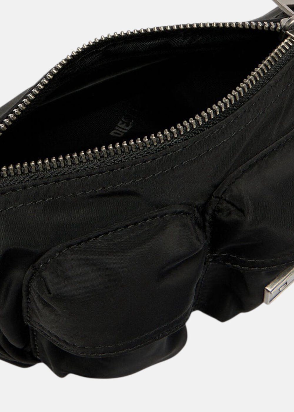 Zoom sur l'ouverture zippée et la doublure intérieure siglée Diesel du sac noir.
