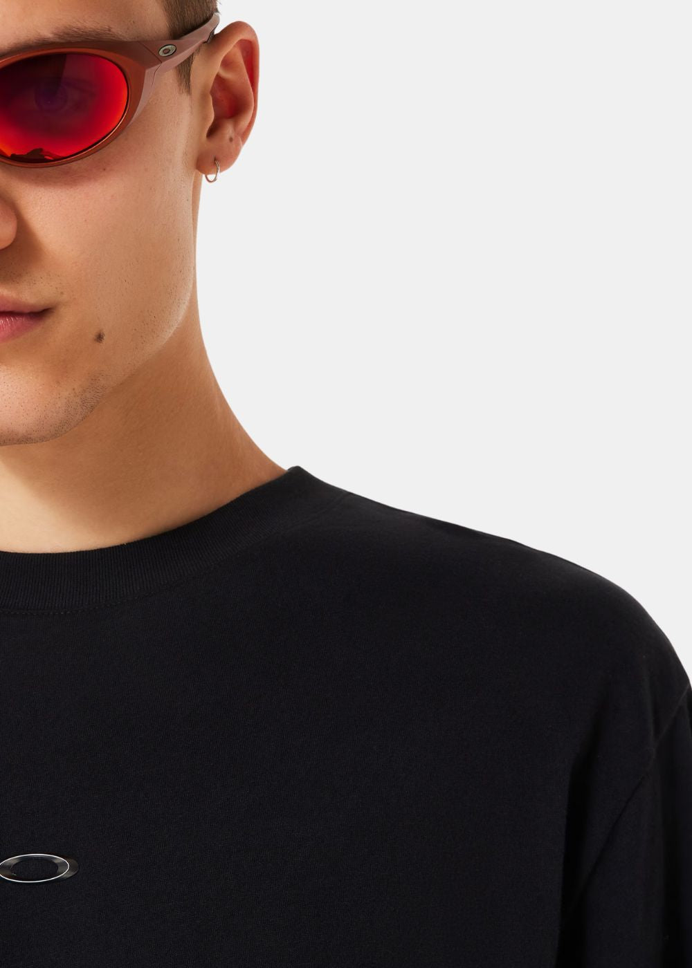 Gros plan sur le logo Oakley Ellipse argenté sur le tissu en coton beige.