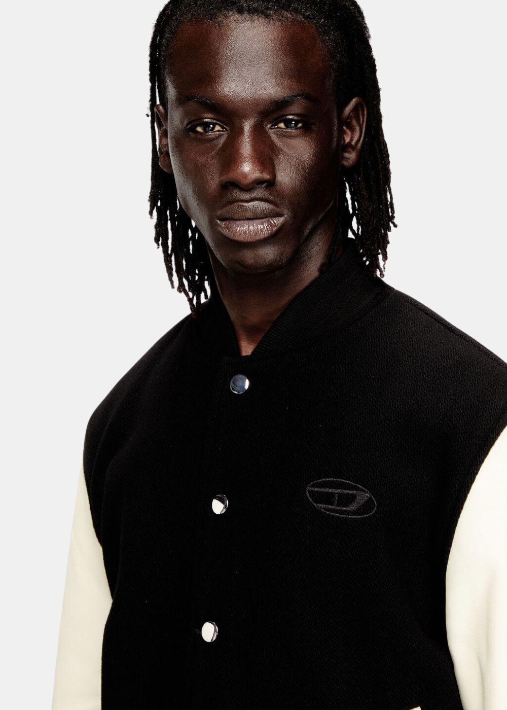 Gros plan sur le logo Oval D brodé ton sur ton sur la poitrine du blouson aviateur Diesel.