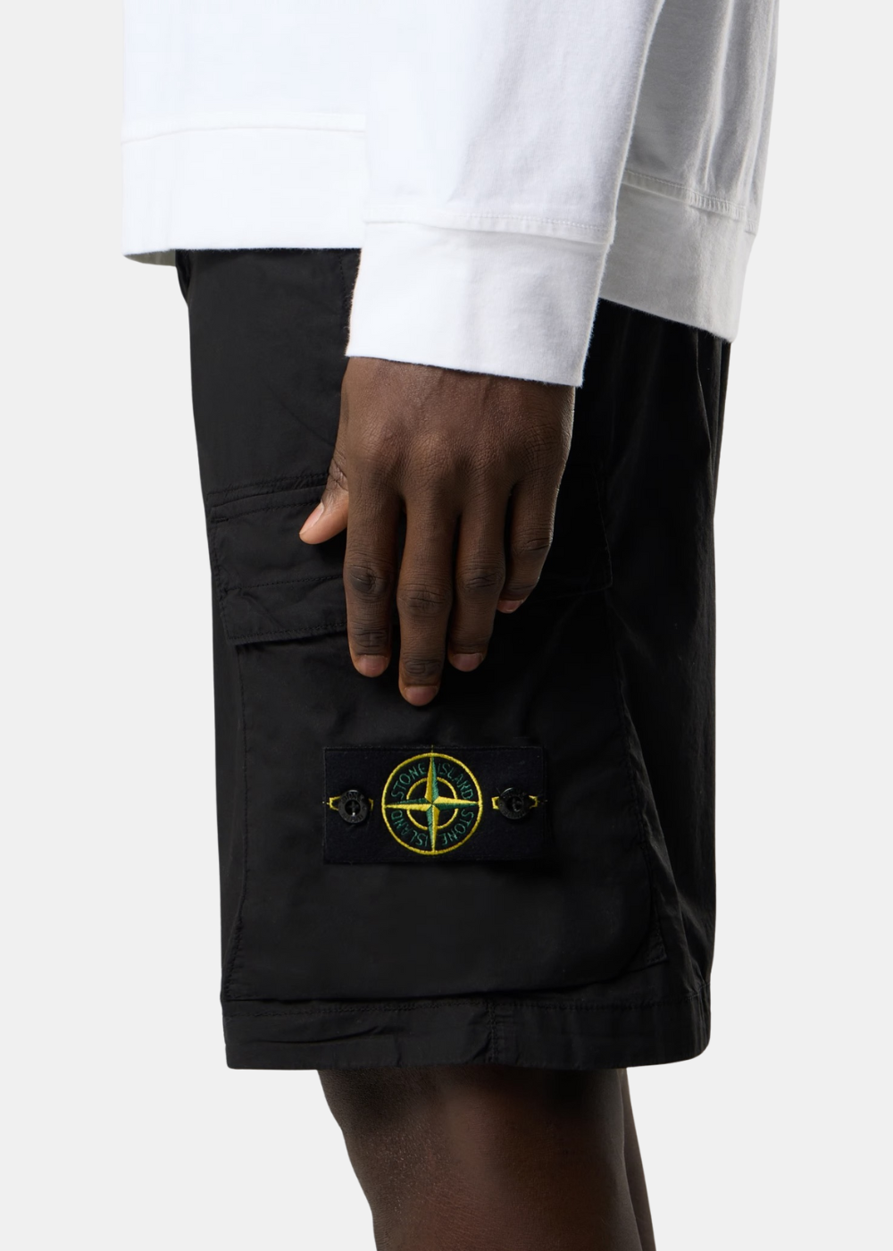 Gros plan sur la poche cargo à rabat avec le patch boussole Stone Island emblématique.
