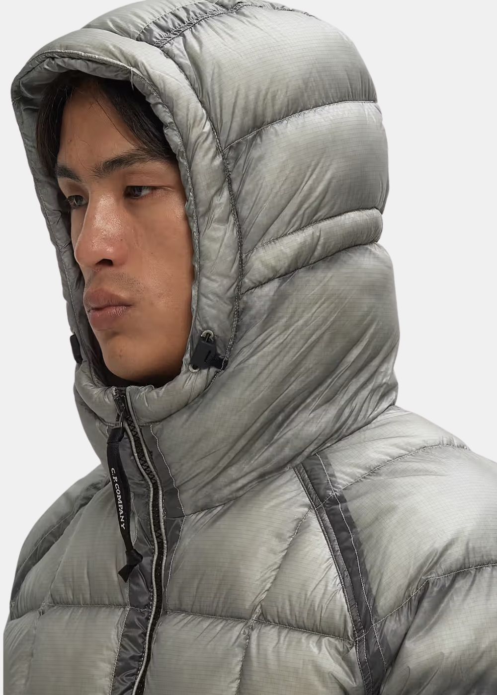 detail de la capuche porté par un mannequin homme de la doudoune cp company dd shell grise vue de profil