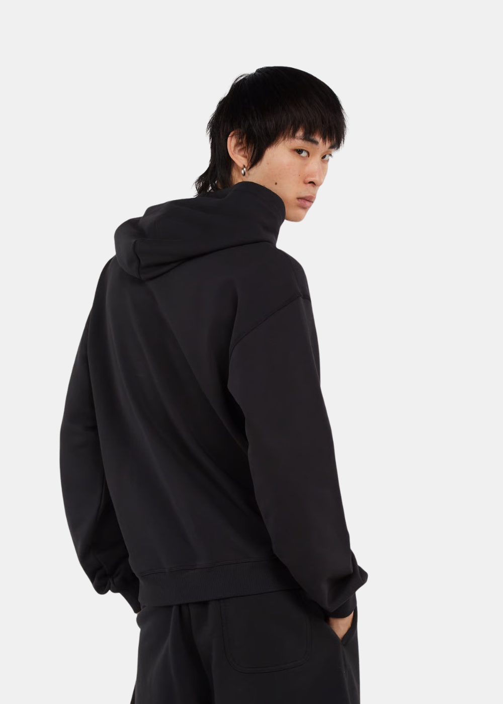 Vue de dos d'un homme portant le sweat à capuche Diesel S-NORM noir avec capuche tombante et coupe ajustée.