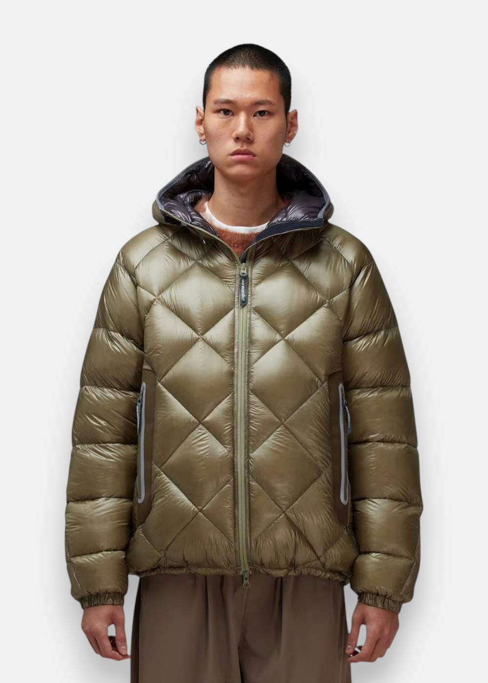 Homme portant la doudoune And Wander vert kaki, grand volume, chaude, idéale pour l'hiver.