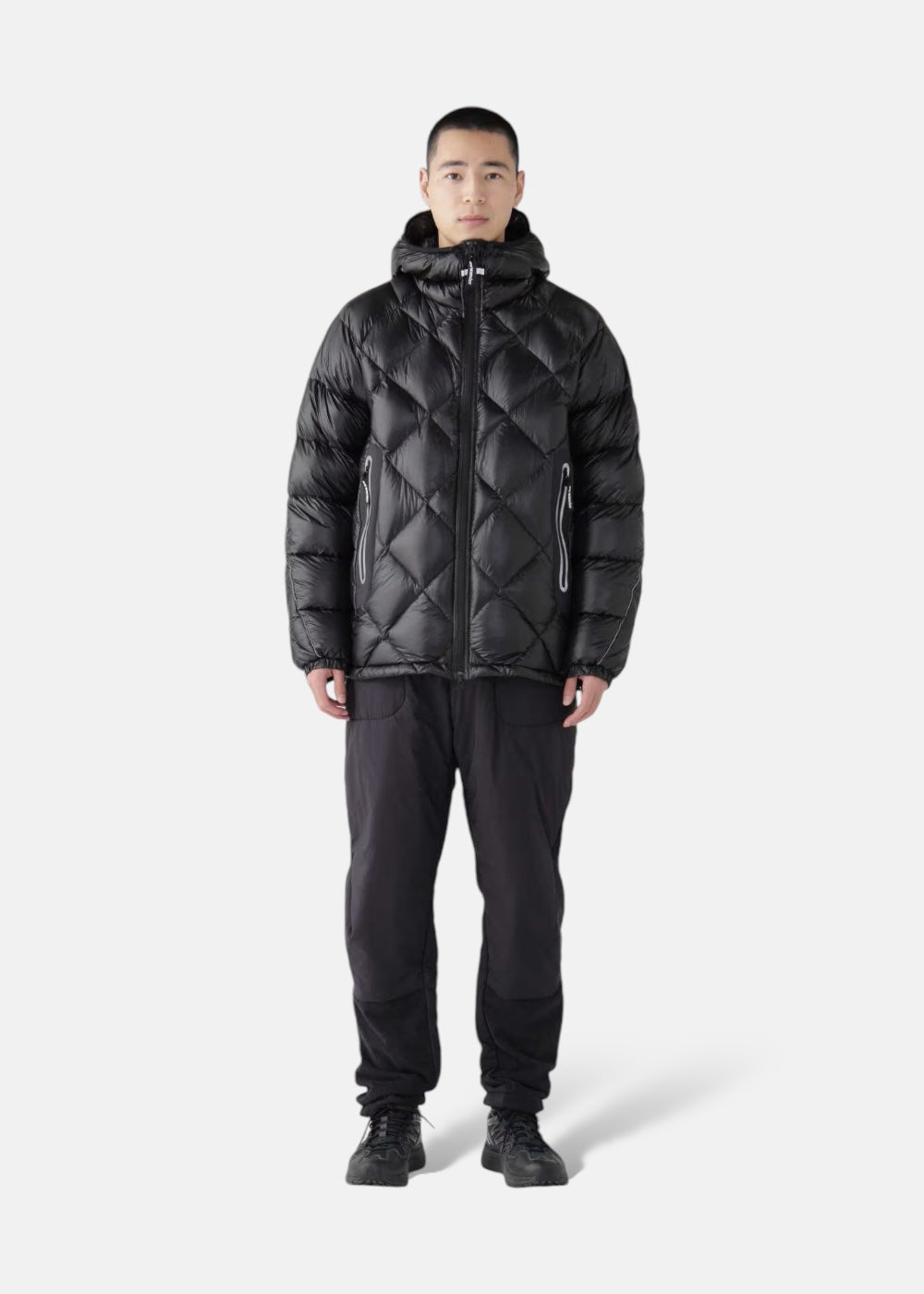 Homme portant la doudoune And Wander noire, matelassage losanges, chaude et légère.