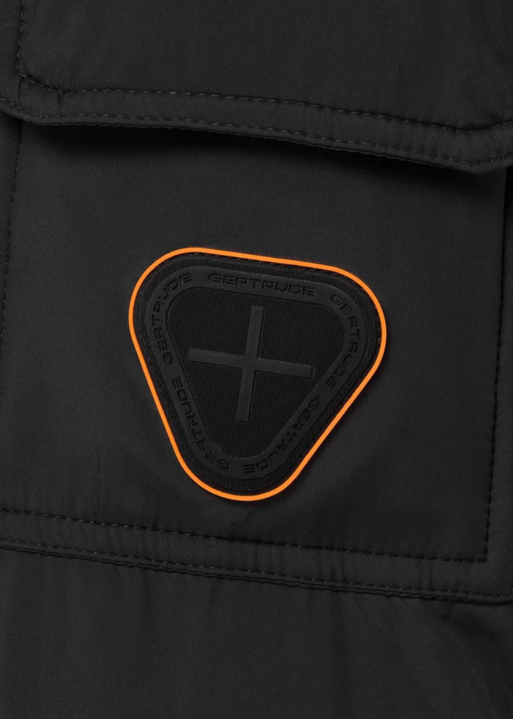 Gros plan sur la poche de manche à rabat et le patch en silicone logo Gertrude   