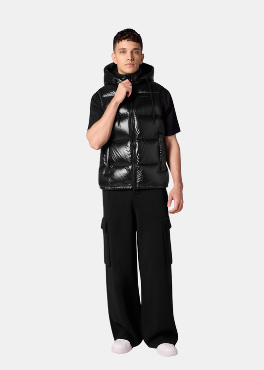 Homme portant la doudoune sans manches Gertrude Cesar noire avec un pantalon cargo large et un t-shirt noir.