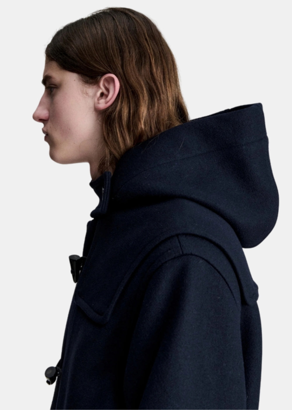 Gros plan de profil sur la capuche large et le col d'un duffle coat A.P.C. Luis en laine marine.