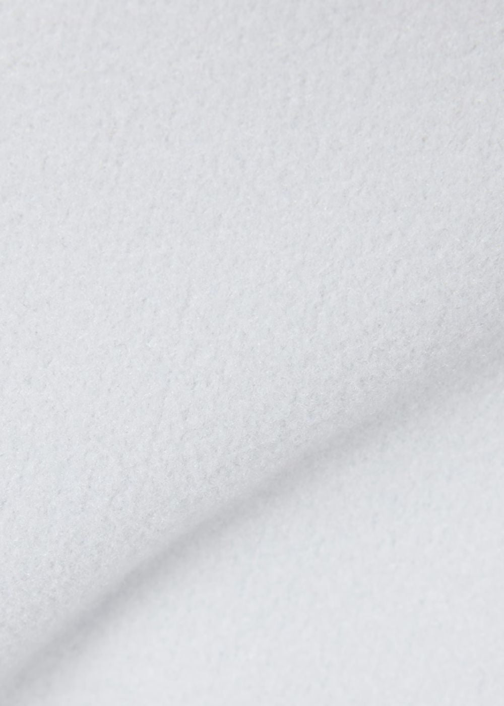 Gros plan sur la texture douce et chaude de la flanelle épaisse gris clair Lacoste.