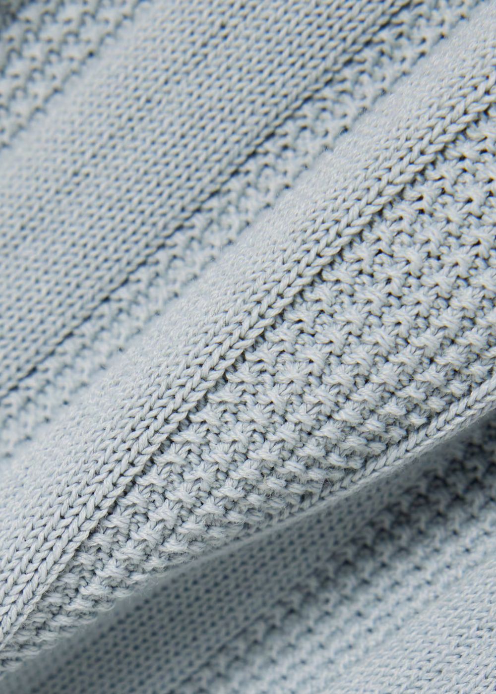 Gros plan sur la maille fluide texturée en viscose et coton du cardigan Lacoste.