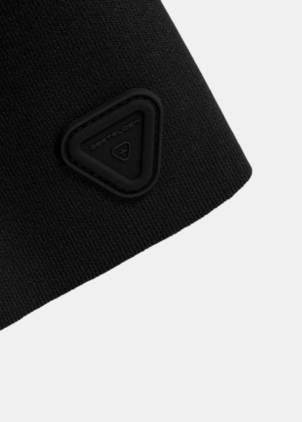 Gros plan sur le patch en silicone noir ton sur ton fixé au bas du polo Gertrude LULU.