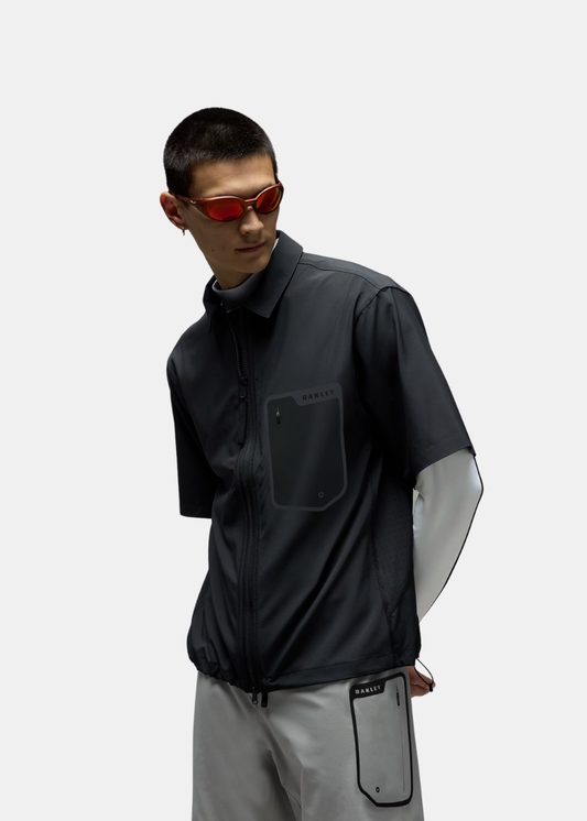 Porté trois-quart face de la chemise zippée Oakley noire avec col classique et poche poitrine.