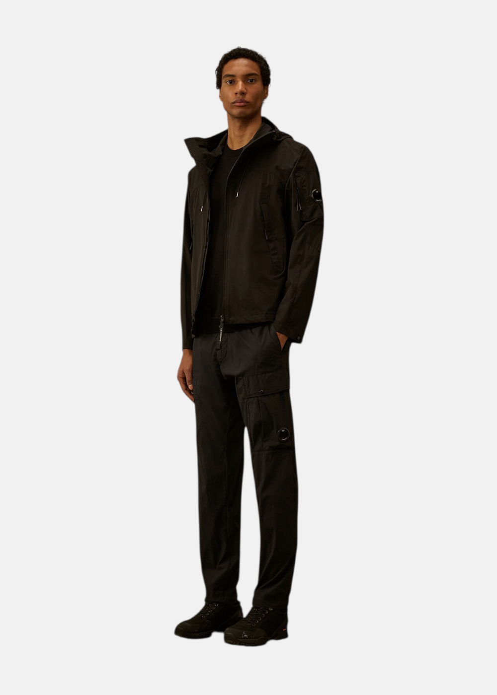 Mannequin portant la veste Pro-Tek noire, un pull olive et un pantalon cargo kaki.
