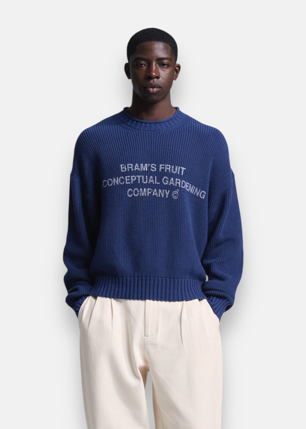 Homme portant de face le pull bleu marine Bram's Fruit en maille côtelée avec lettrage blanc sur le torse.