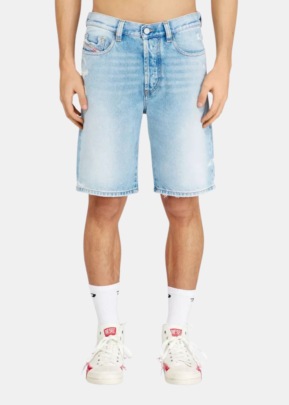 Short en denim bleu clair Diesel porté par un homme. Coupe droite au-dessus du genou avec revers aux ourlets. Vue de face.