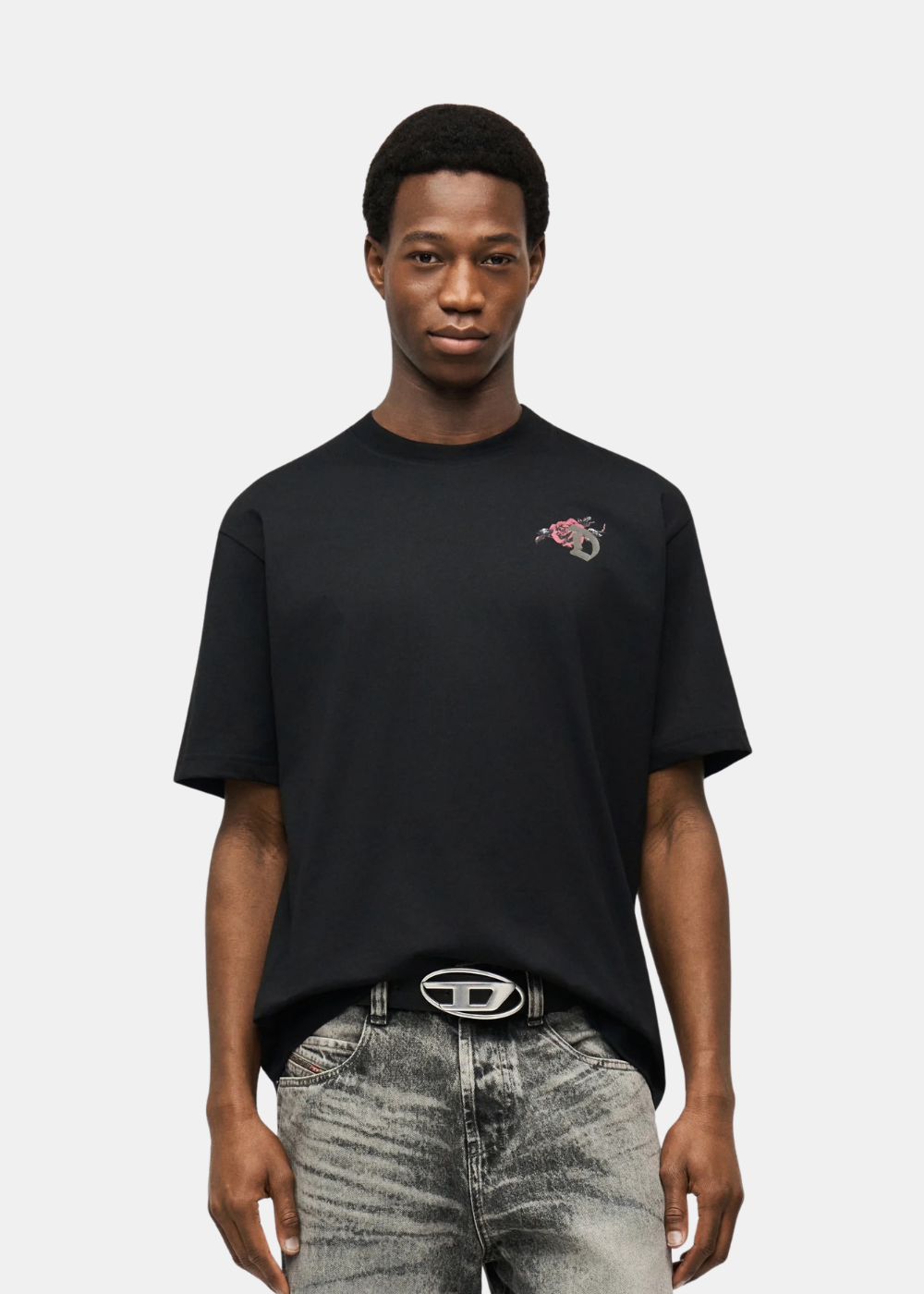 T-shirt homme Diesel noir avec petit logo floral sur la poitrine porté de face.