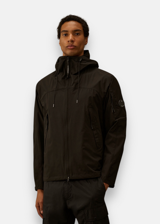 Homme portant la veste noire C.P. Company Pro-Tek zippée avec capuche ajustée.