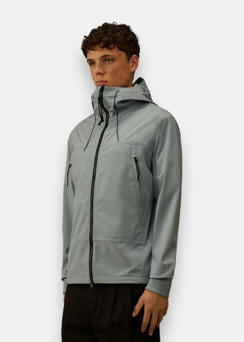 Homme portant la veste Shell-R bleu silver fermée avec capuche Goggle et poches poitrine zippées.