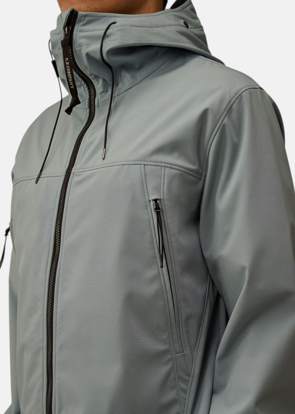 Détail de la fermeture éclair centrale noire et de la poche zippée sur la veste C.P. Company bleu silver.