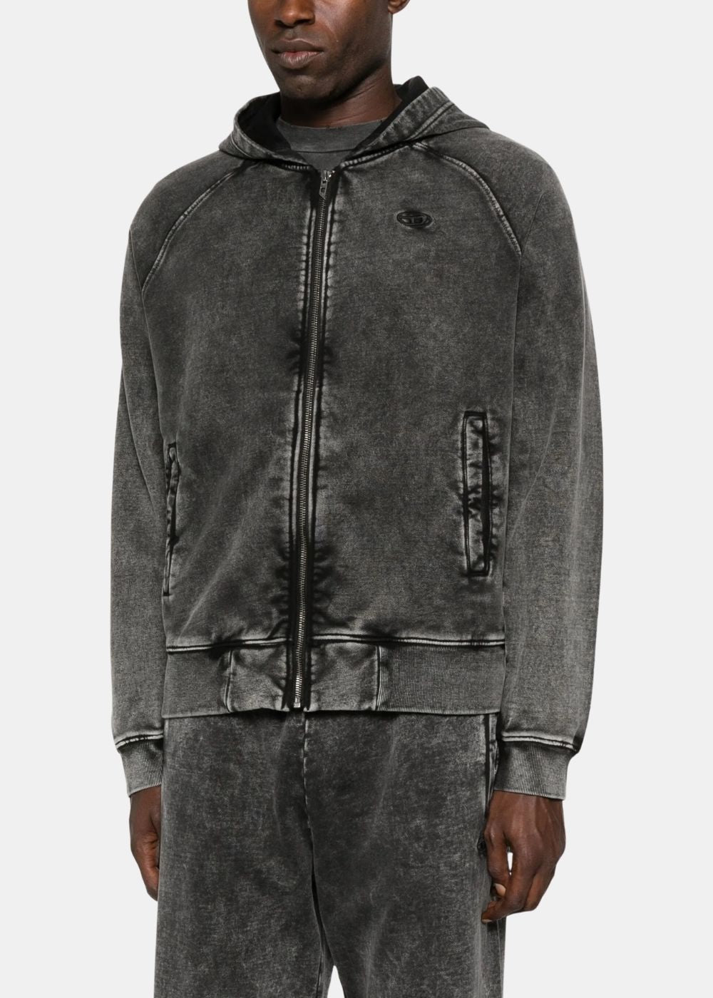Détail du hoodie zippé Diesel gris foncé porté, mettant en avant la fermeture éclair métallique et la coupe des manches raglan.