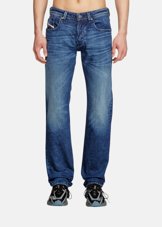 Jean bleu Diesel 1985 Larkee en coton régénératif de coupe droite, porté par un mannequin de face avec des baskets noires