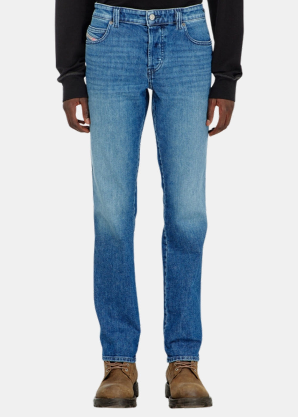 Porté de face d'un jean slim bleu Diesel D-vyl 1993, taille naturelle et jambe droite, avec chaussures marron.