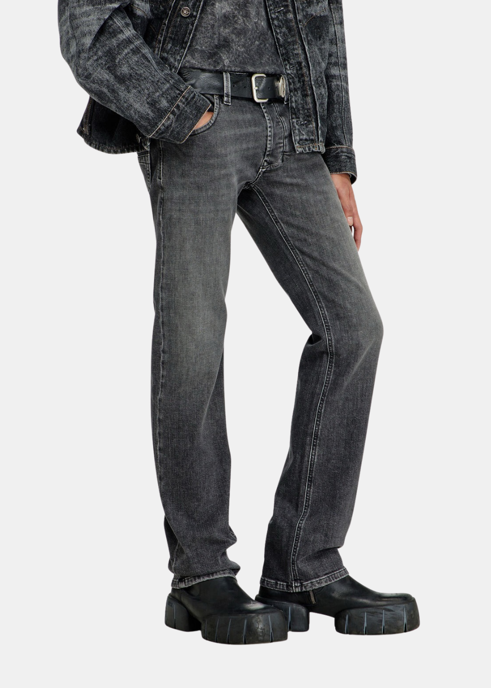 Gros plan sur le bas du corps d'un mannequin portant le jean Diesel gris délavé, de profi