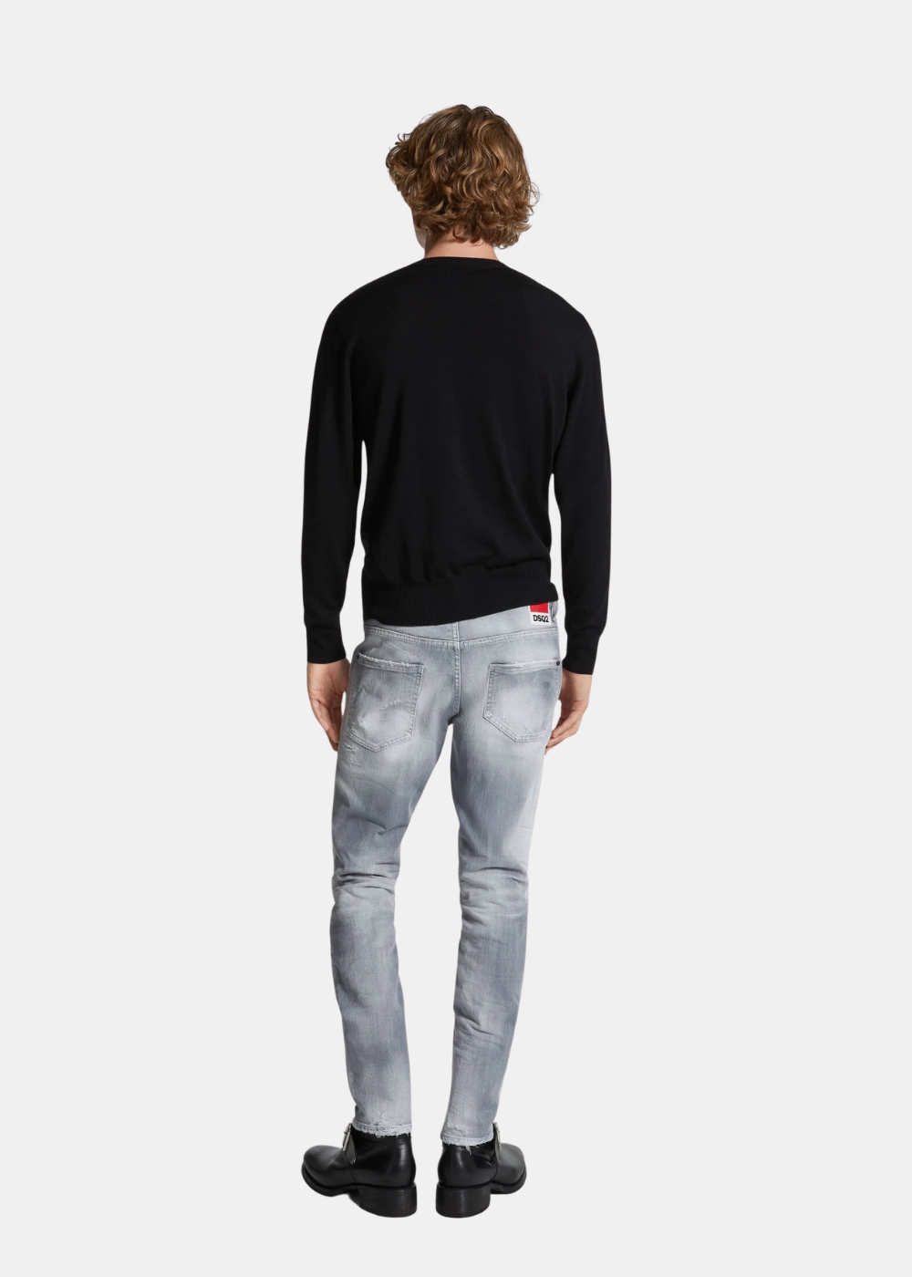Mannequin de dos portant le jean Dsquared2 gris délavé avec un pull noir et des bottines noires.