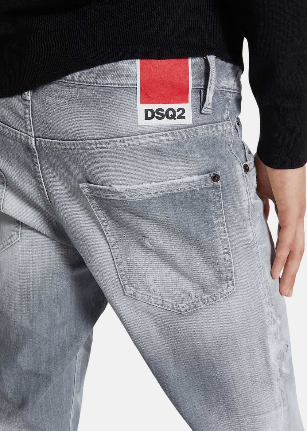 Gros plan dos d'un mannequin portant le jean Dsquared2 gris, montrant une poche arrière usée et l'étiquette rouge DSQ2.