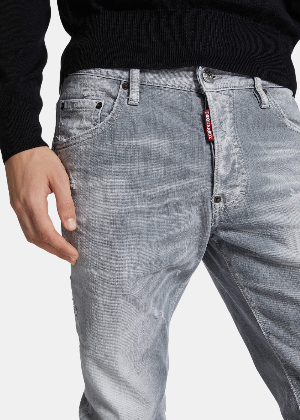 Gros plan face d'un mannequin portant le jean Dsquared2 gris, montrant la braguette à boutons et l'étiquette rouge Dsquared2.