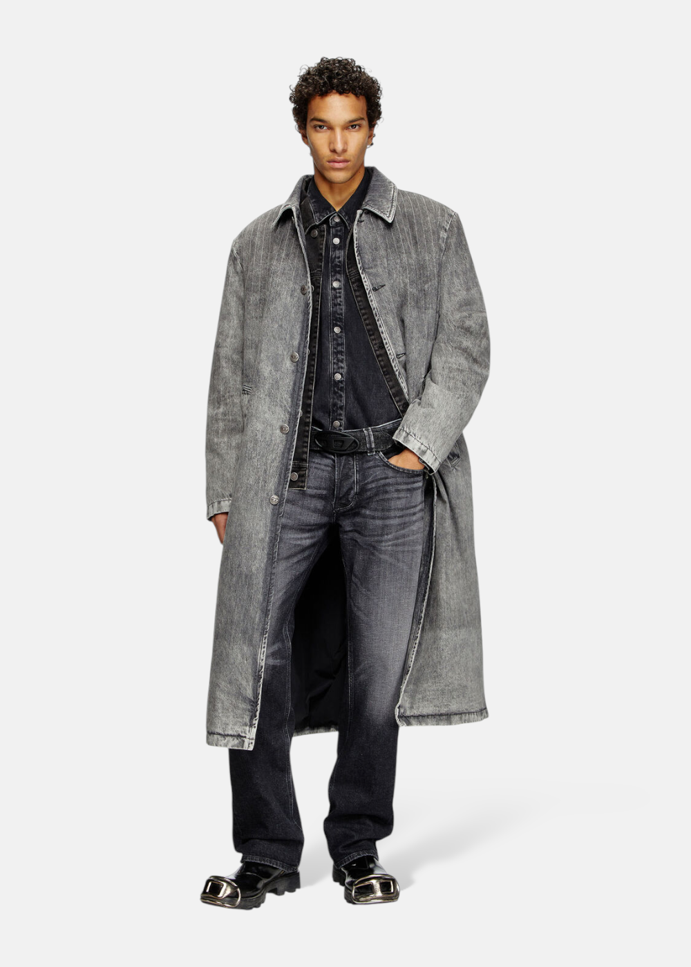 Homme portant le Jeans Diesel 1985 Larkee regular noir sous un long manteau gris, look complet.