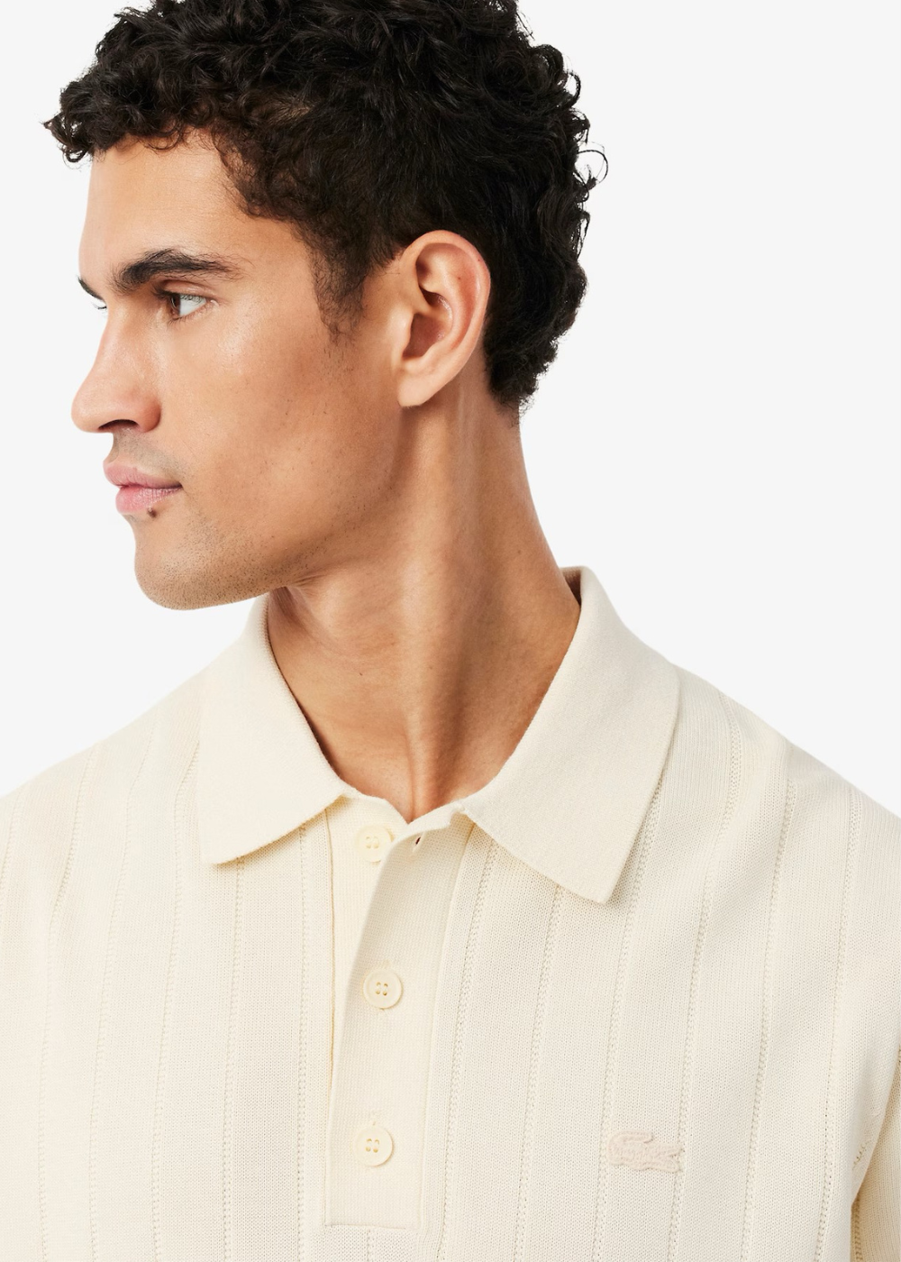 Vue de profil du polo Lacoste beige porté, montrant la fluidité.