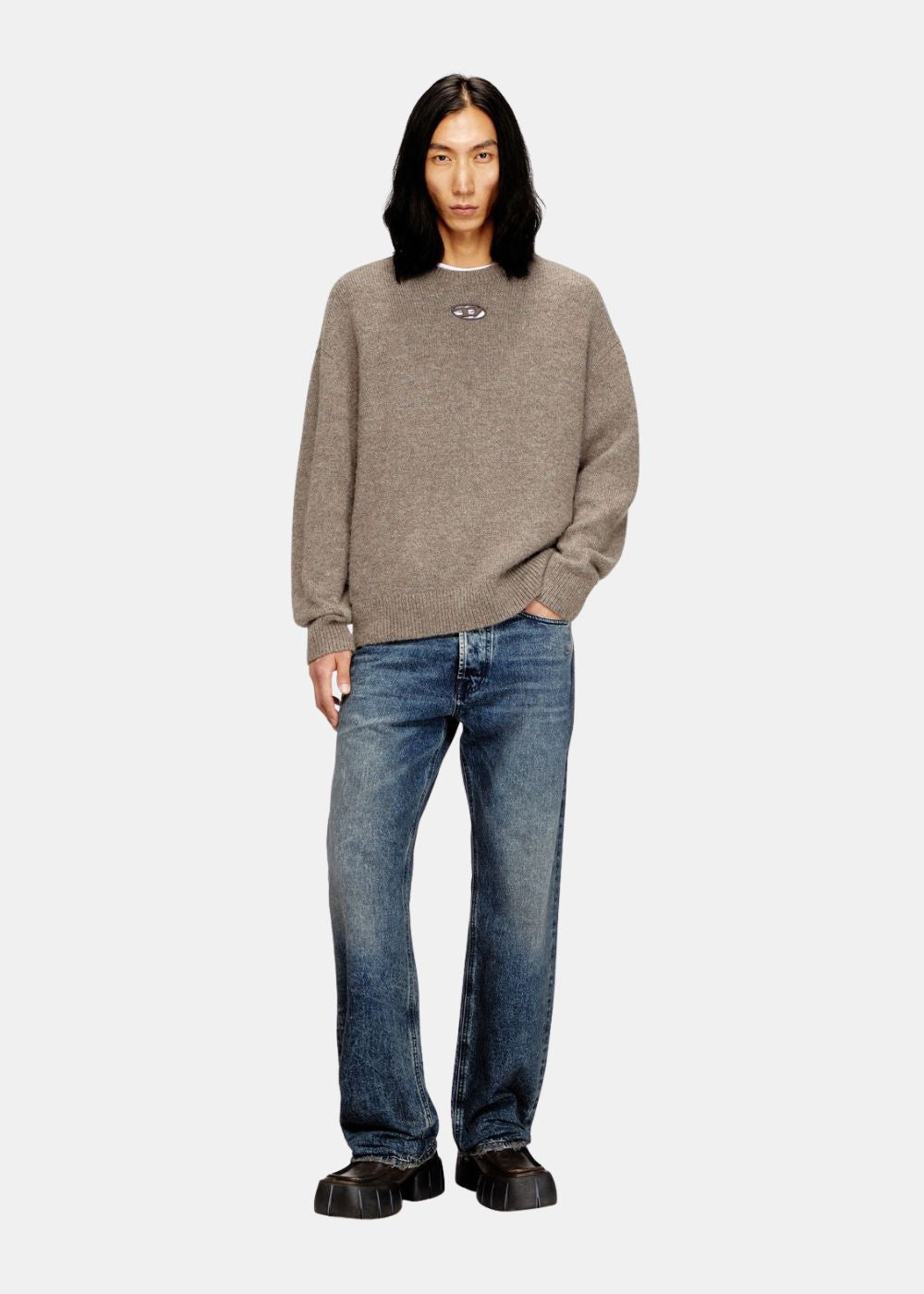 Mannequin portant le pull Diesel K-Areeso brun avec un jean bleu, montrant la coupe classique et décontractée.