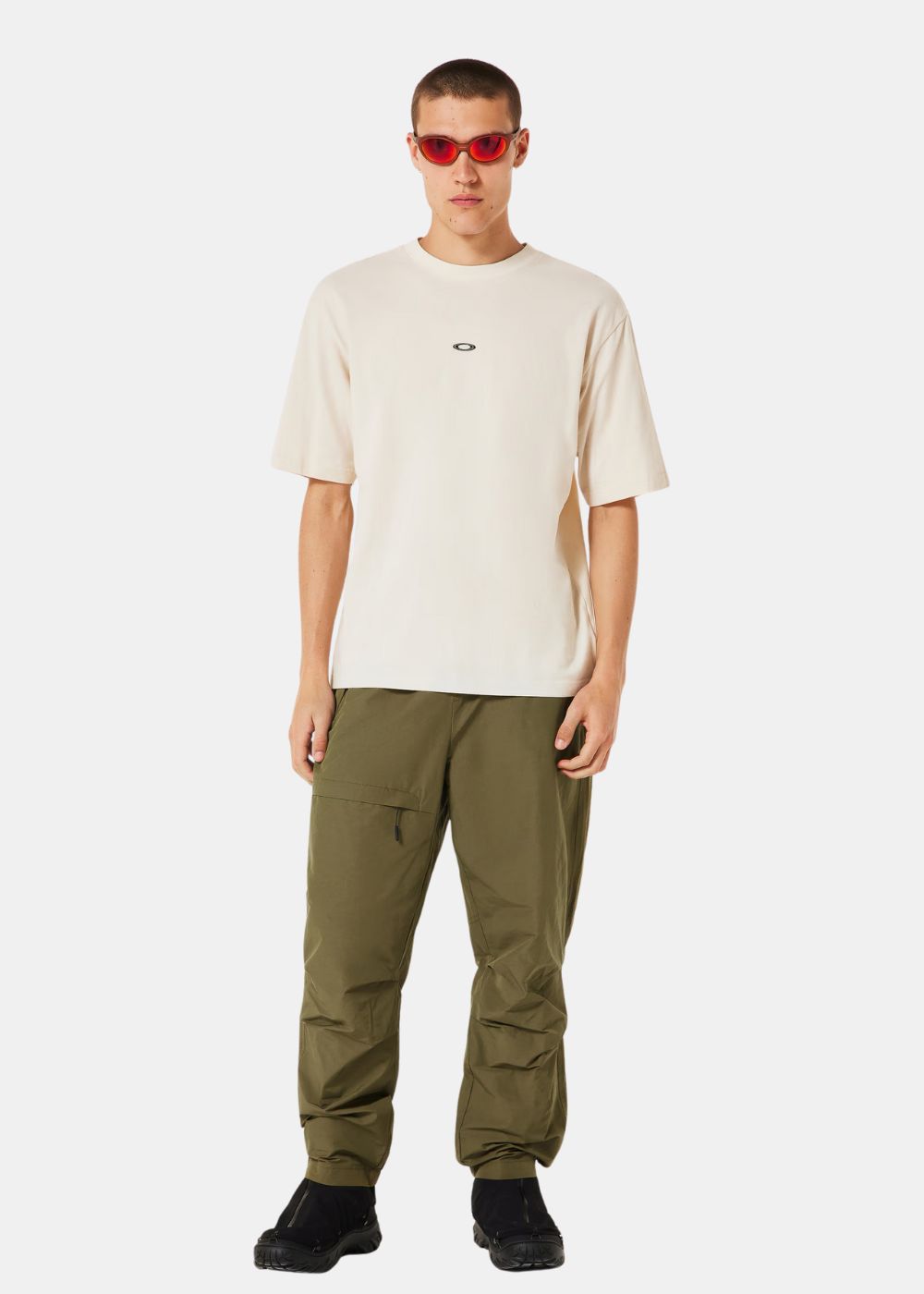  t-shirt beige Oakley porté associé à un pantalon kaki, illustrant le contraste des couleurs.