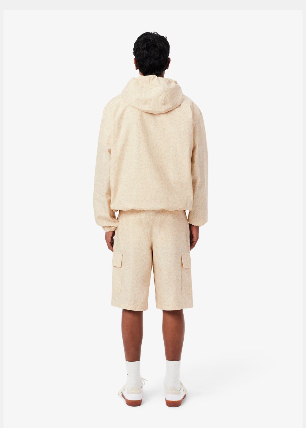 vue de dos d'un mannequin debout habillé du Short cargo Lacoste beige imprimé et de sa veste enfilable