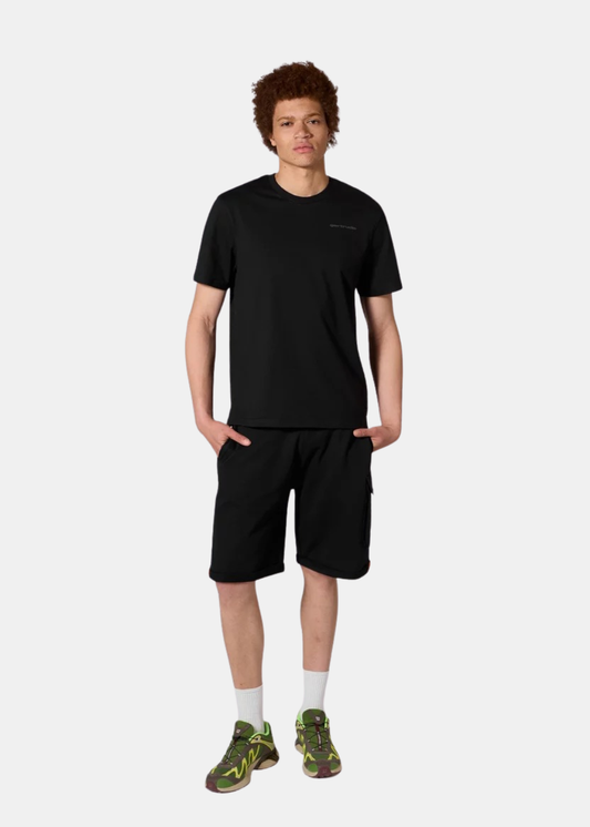 Mannequin homme de face portant le t-shirt noir Gertrude, un short noir, des chaussettes hautes blanches et des baskets vertes.
