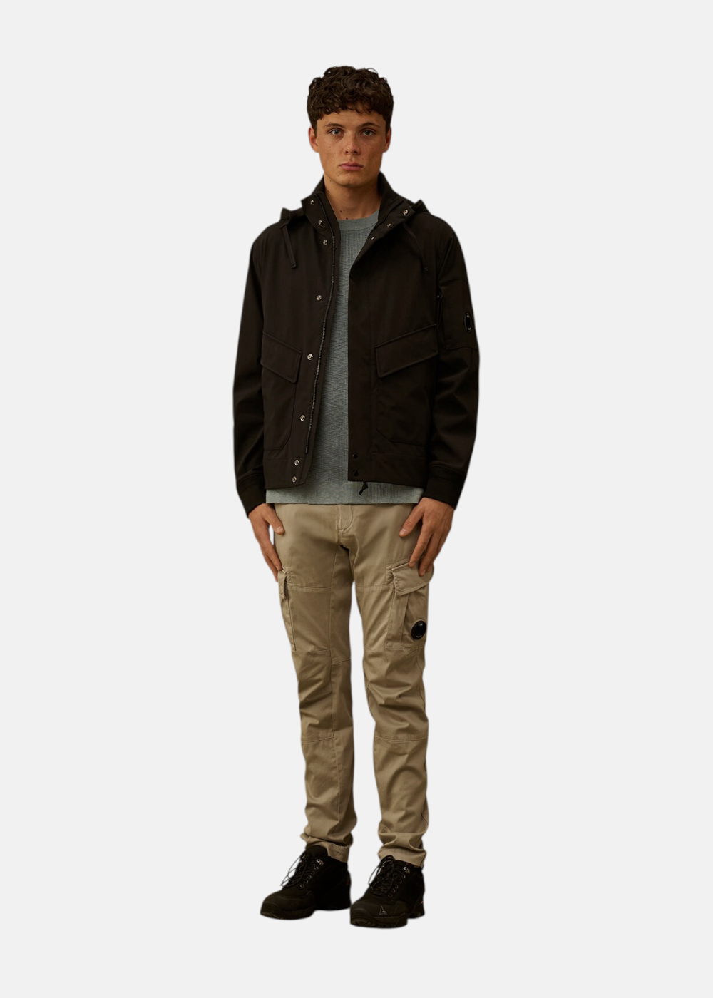 Mannequin portant le pantalon cargo beige C.P. Company avec une veste noire et des baskets