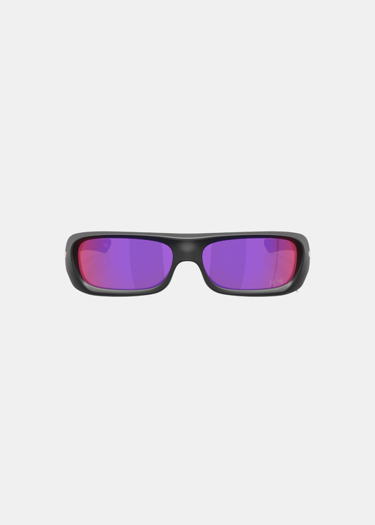 Packshot de face des lunettes de soleil Oakley Permian Mbappé, mettant en valeur la forme rectangulaire de la monture et l'éclat des verres miroirs Prizm Road violets et roses gravés des initiales KM sur le verre gauche