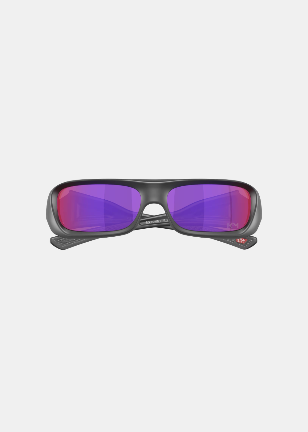 Packshot de face des lunettes Oakley Permian Mbappé avec les branches repliées vers l'intérieur, révélant le numéro de série gravé sur le pont arrière, les plaquettes de nez et la mention rouge USA Made sur la branch