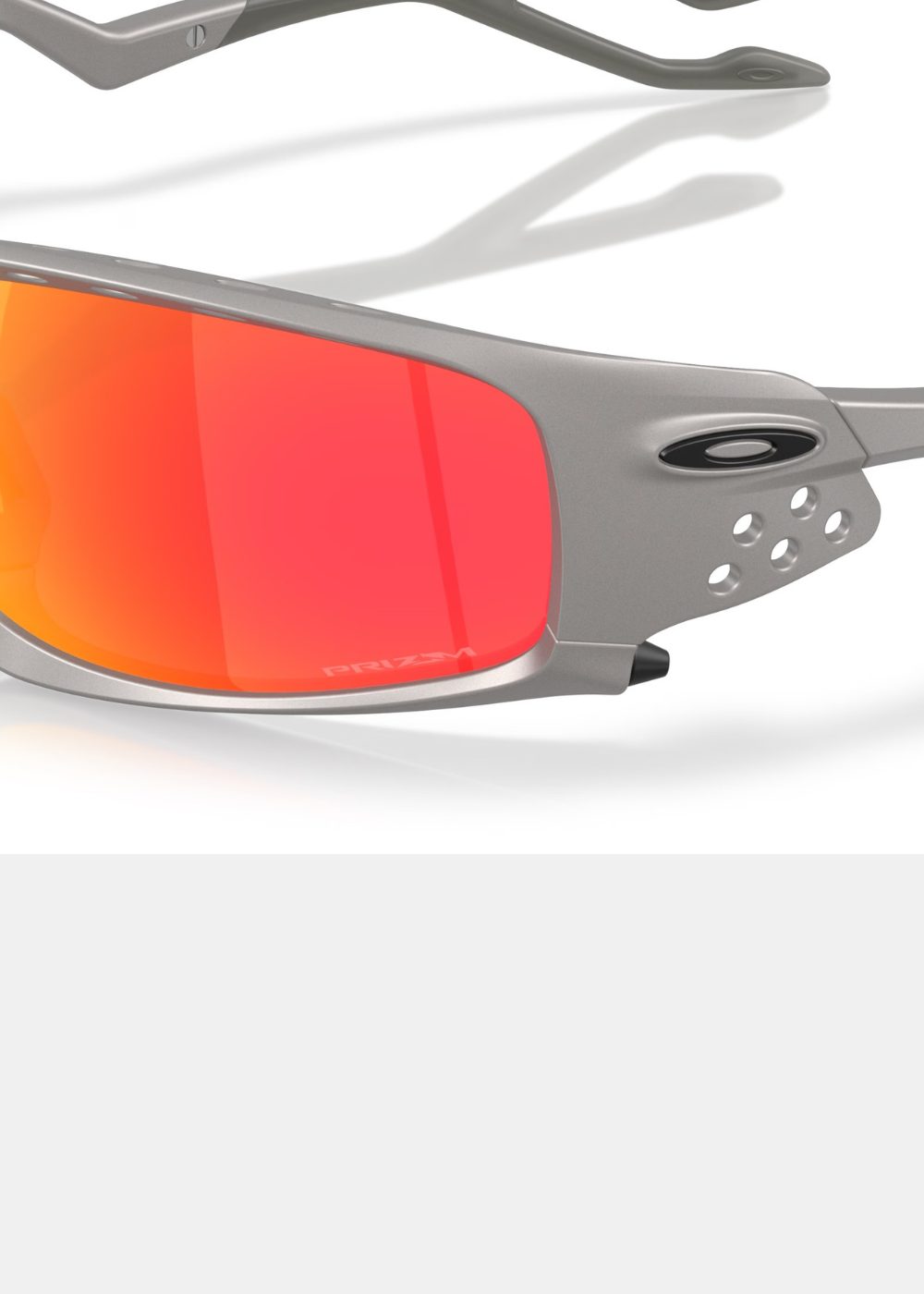 Gros plan détaillé sur le verre Prizm Ruby rouge des lunettes Oakley Plantaris SQ, mettant en évidence la finition argent mat de la monture, l'icône Oakley noire et les détails des aérations latérales