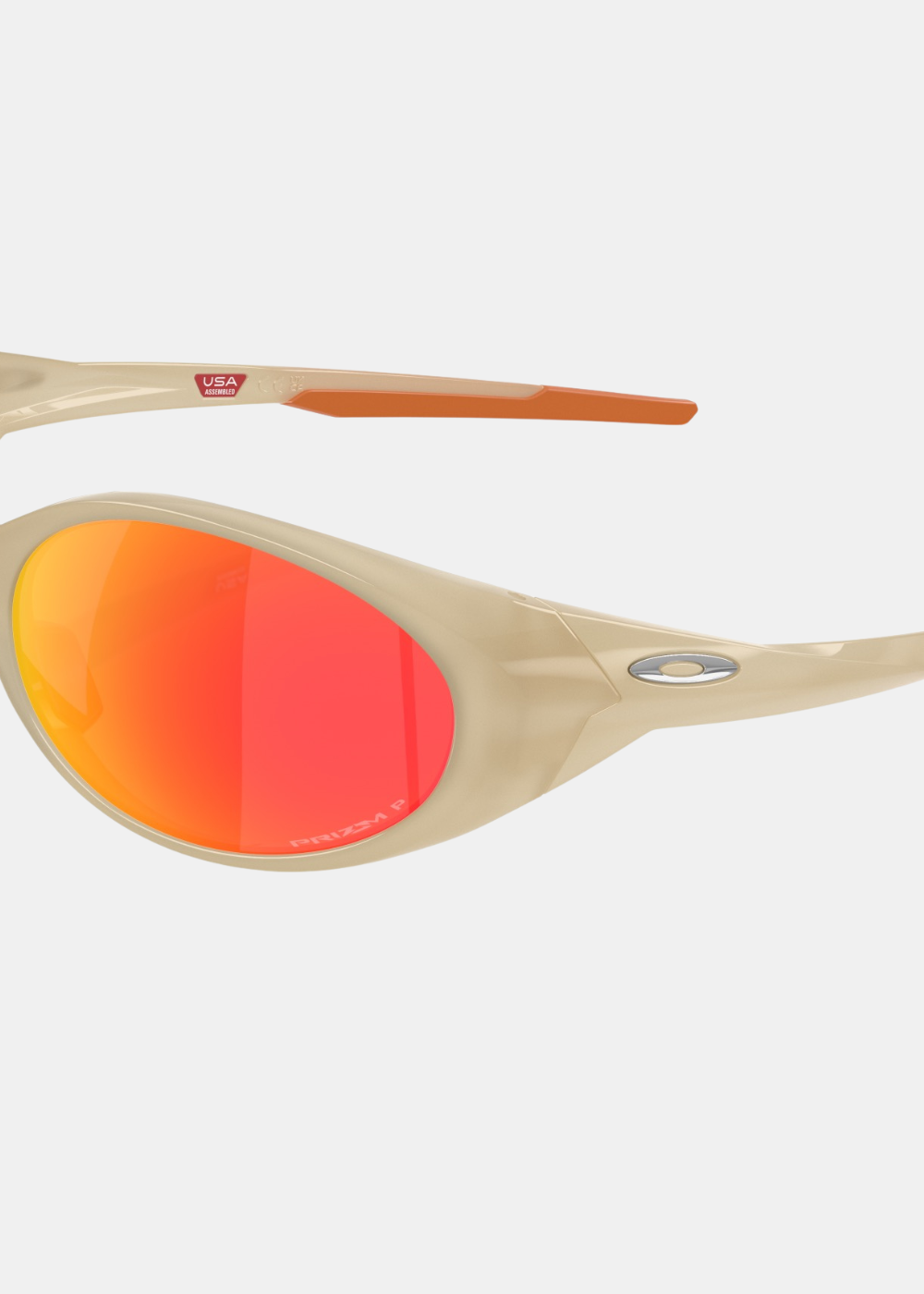 Gros plan sur le verre polarisé Prizm Ruby et l'ellipse métallique Oakley argentée sur la branche beige.