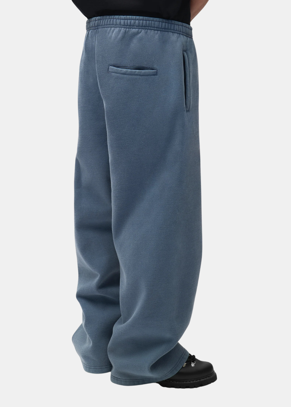 Vue arriere du pantalon de sport bleu délavé Arte Antwerp révélant l'imprimé logo style pochoir.