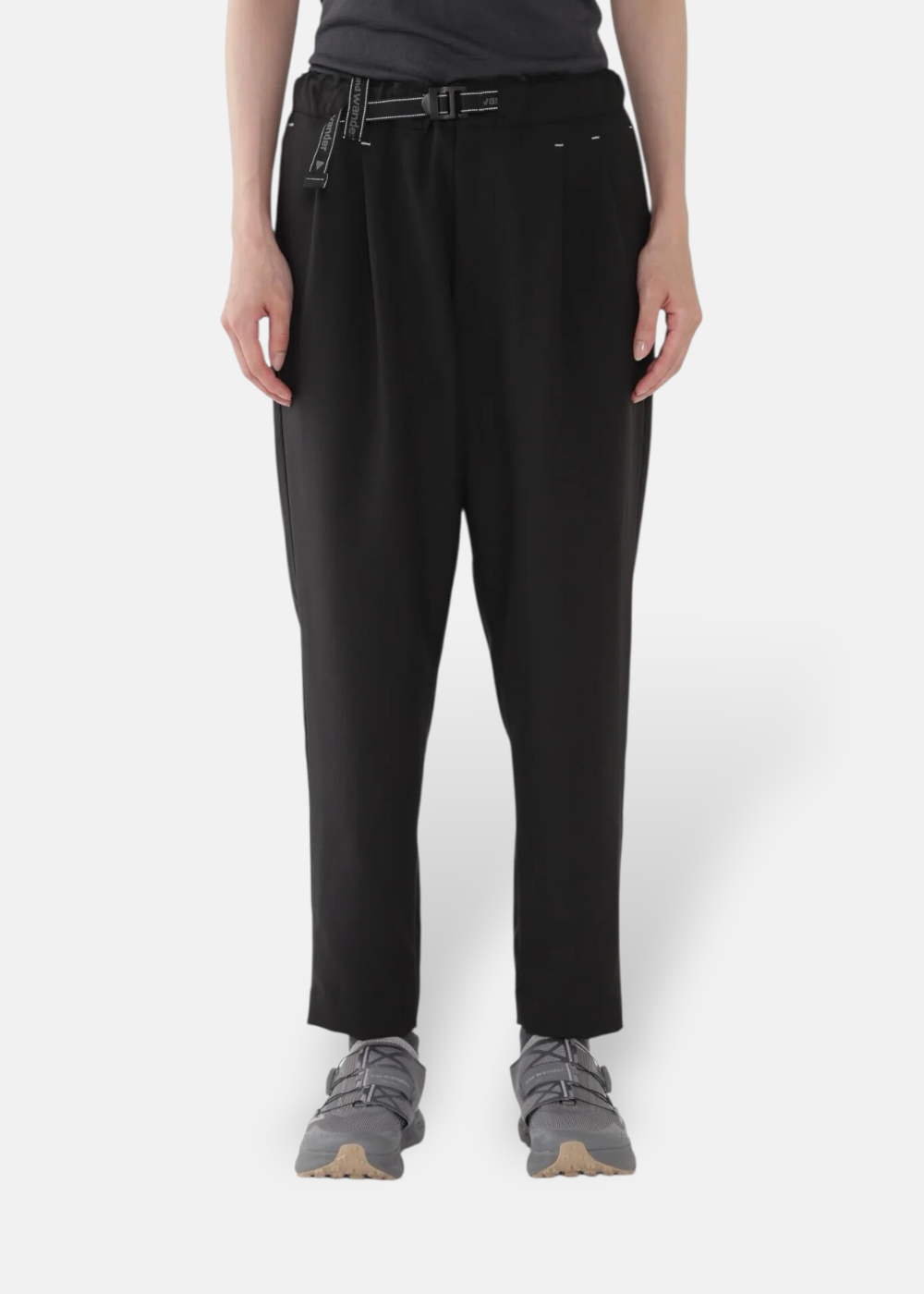 Femme portant le pantalon And Wander noir coupe droite, pour un look lifestyle et outdoor.