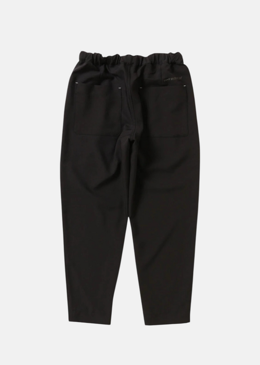 Vue arrière du pantalon And Wander noir, montrant la taille élastique et les poches plaquées.