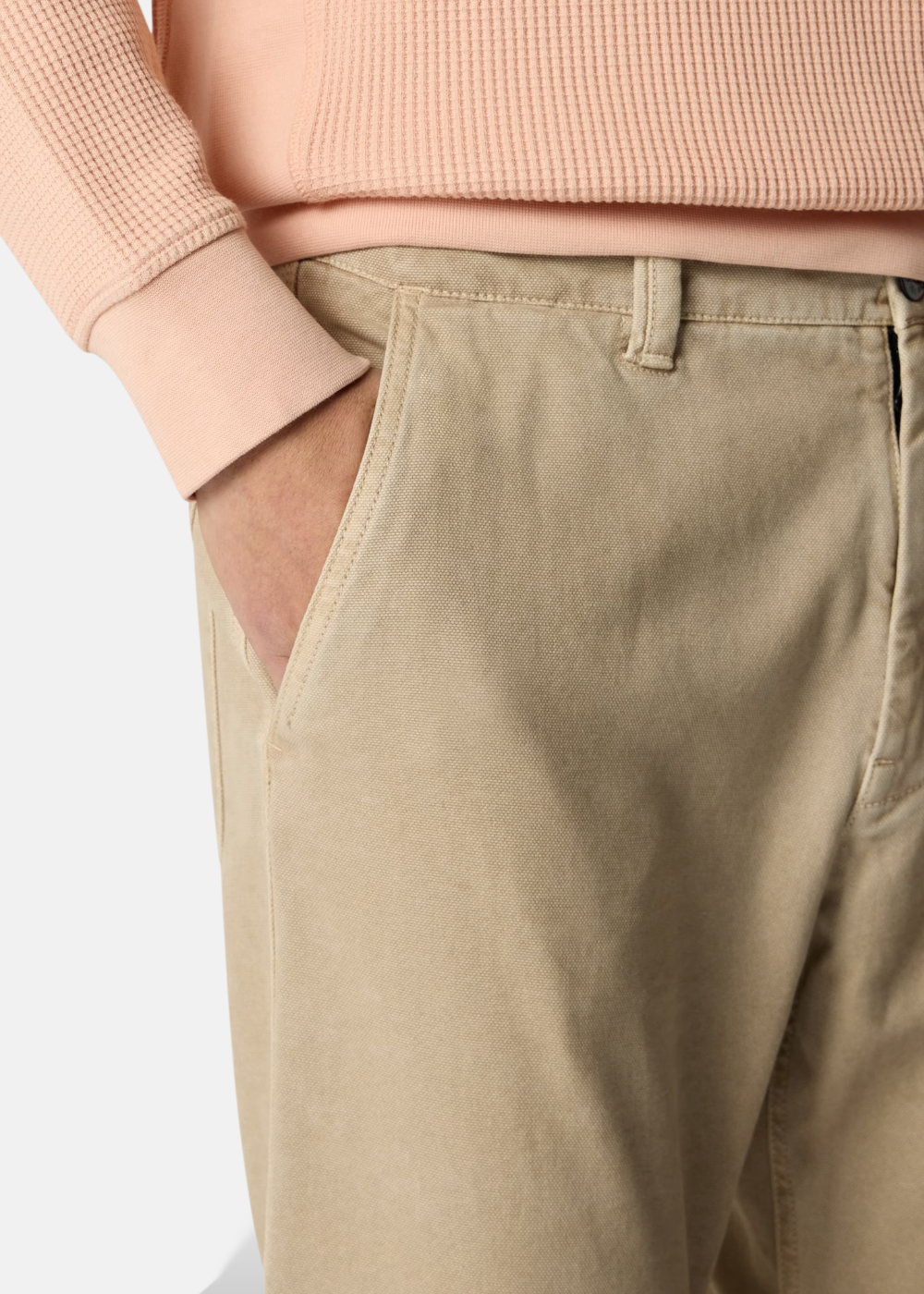 Vue rapprochée de la poche italienne et de la texture Panama d'un pantalon beige Stone Island porté.