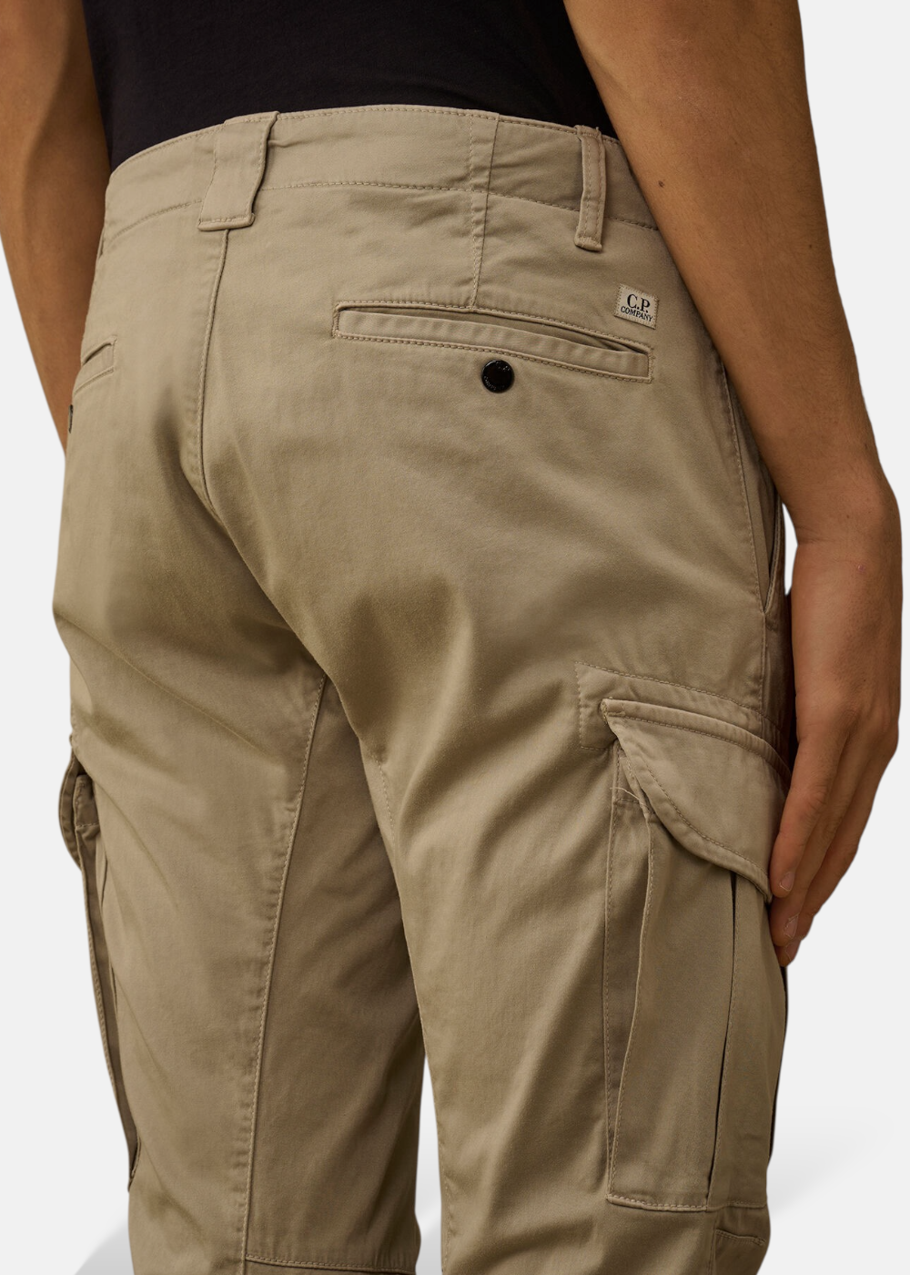 Vue rapprochée de l'arrière du pantalon cargo beige C.P. Company avec logo brodé au-dessus de la poche