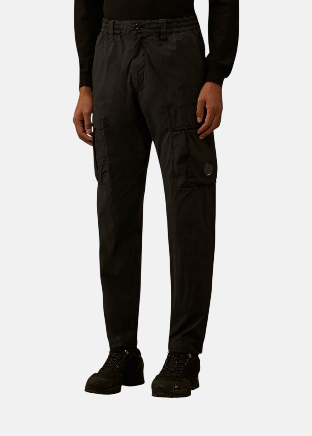 Pantalon cargo noir C.P. Company porté par un mannequin, mettant en avant les poches à soufflet et le tombé.