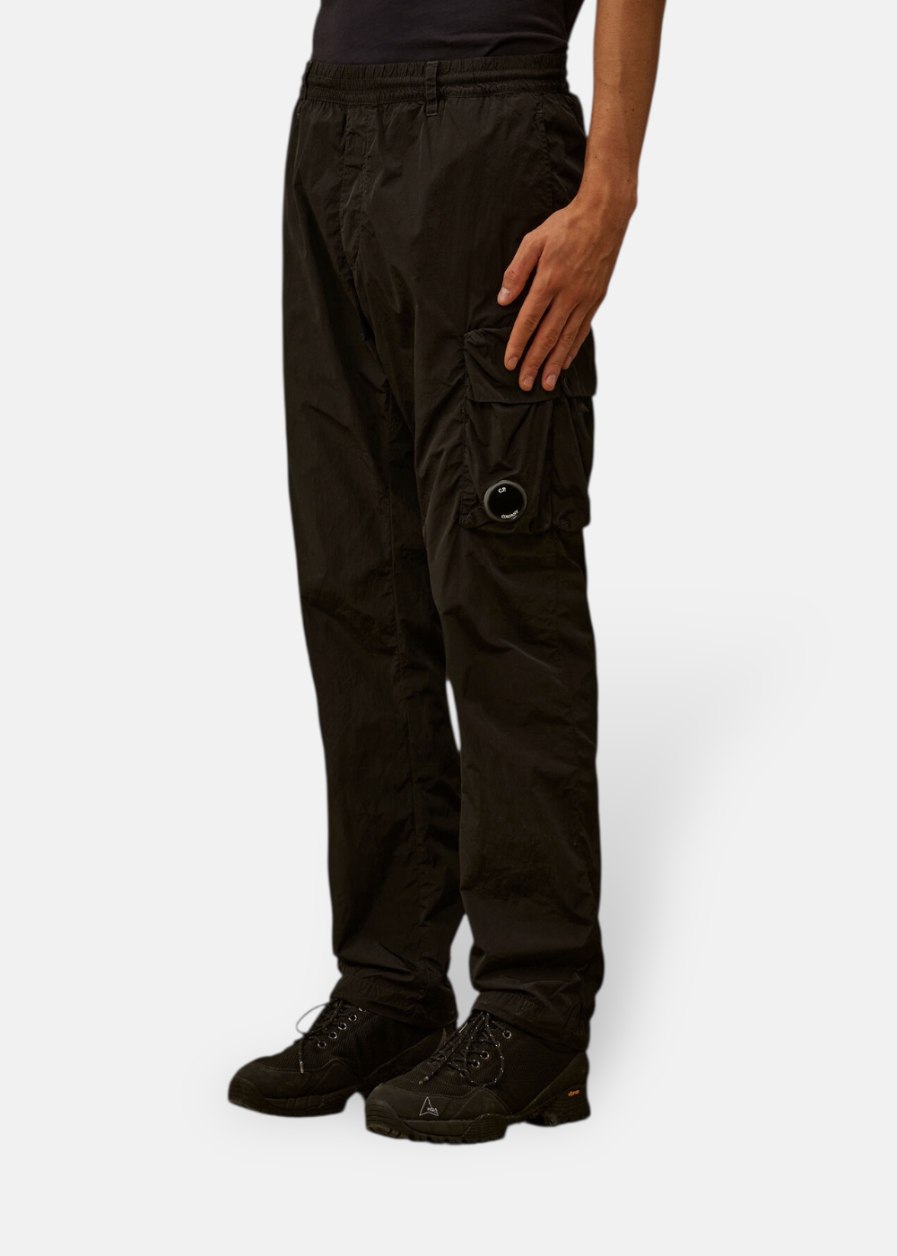 Pantalon cargo noir C.P. Company porté de face par un mannequin mettant en avant la coupe et les poches.