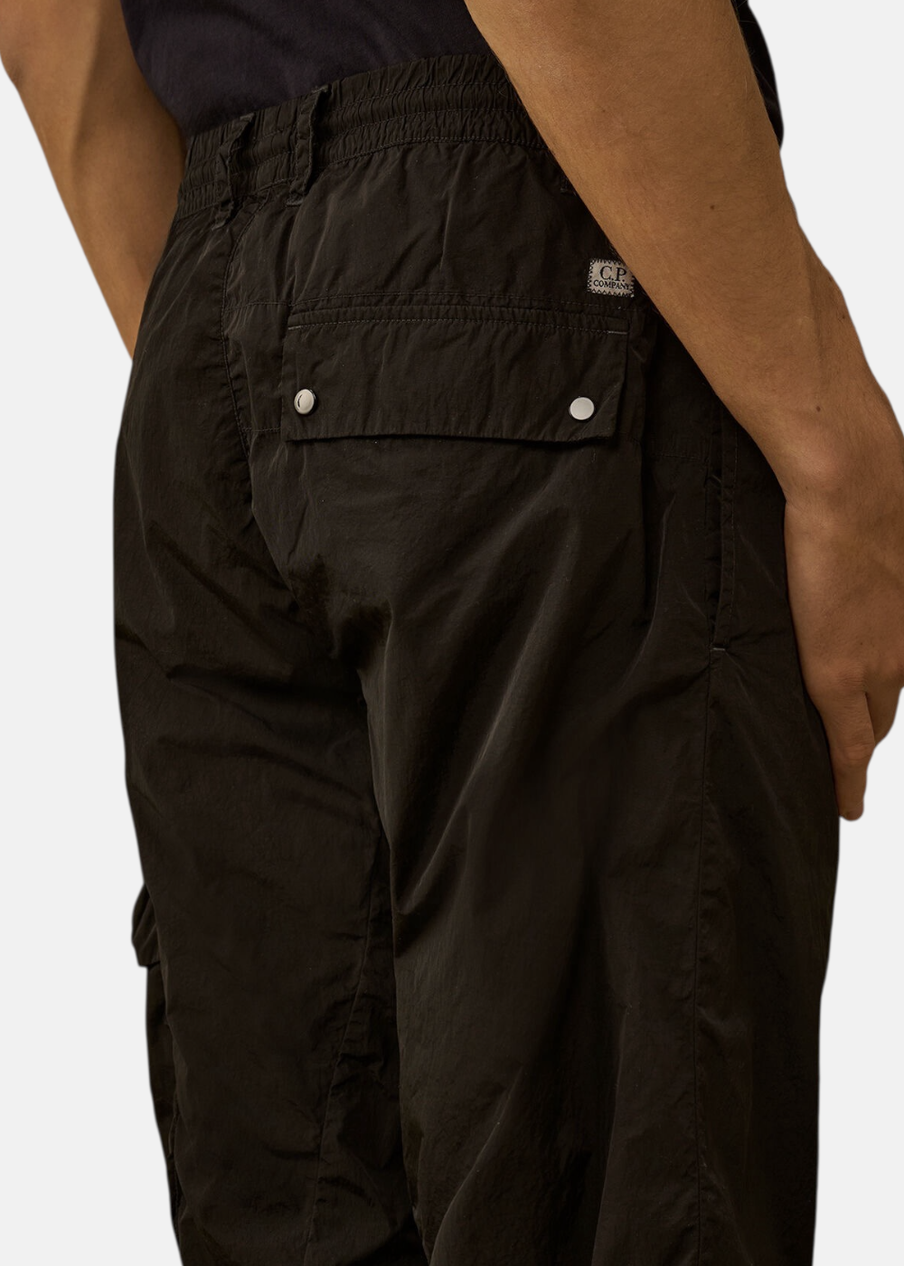 Zoom sur le textile Chrome-R noir brillant et résistant du pantalon cargo C.P. Company.