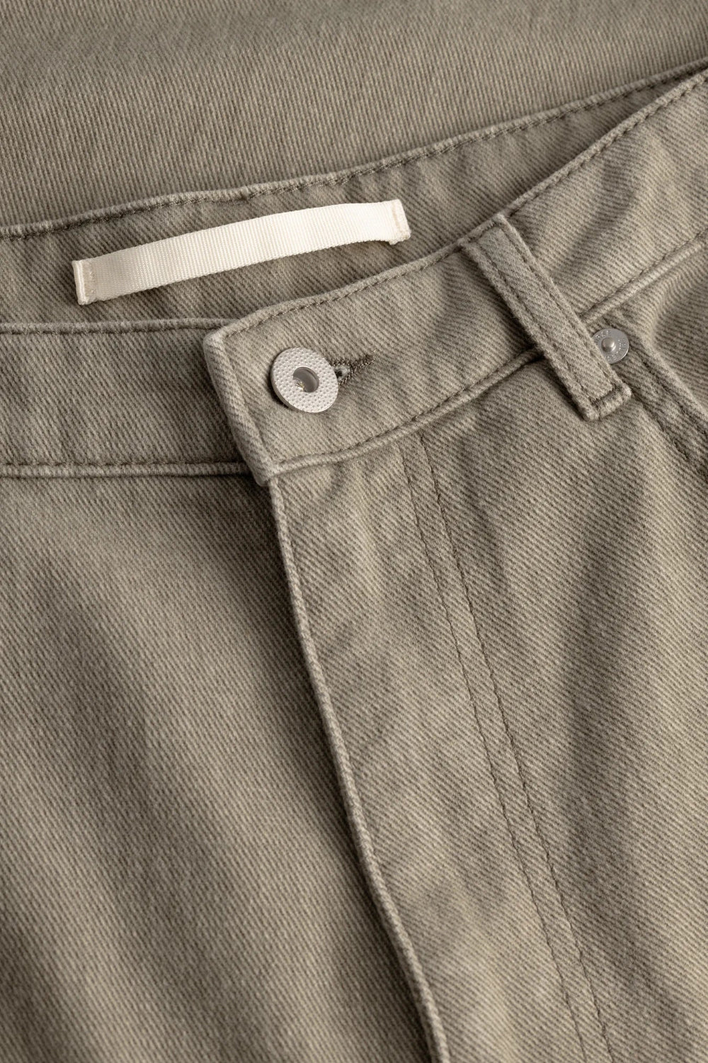 Zoom sur la taille du pantalon Homme Norse Projects kaki avec bouton métallique et passants de ceinture.